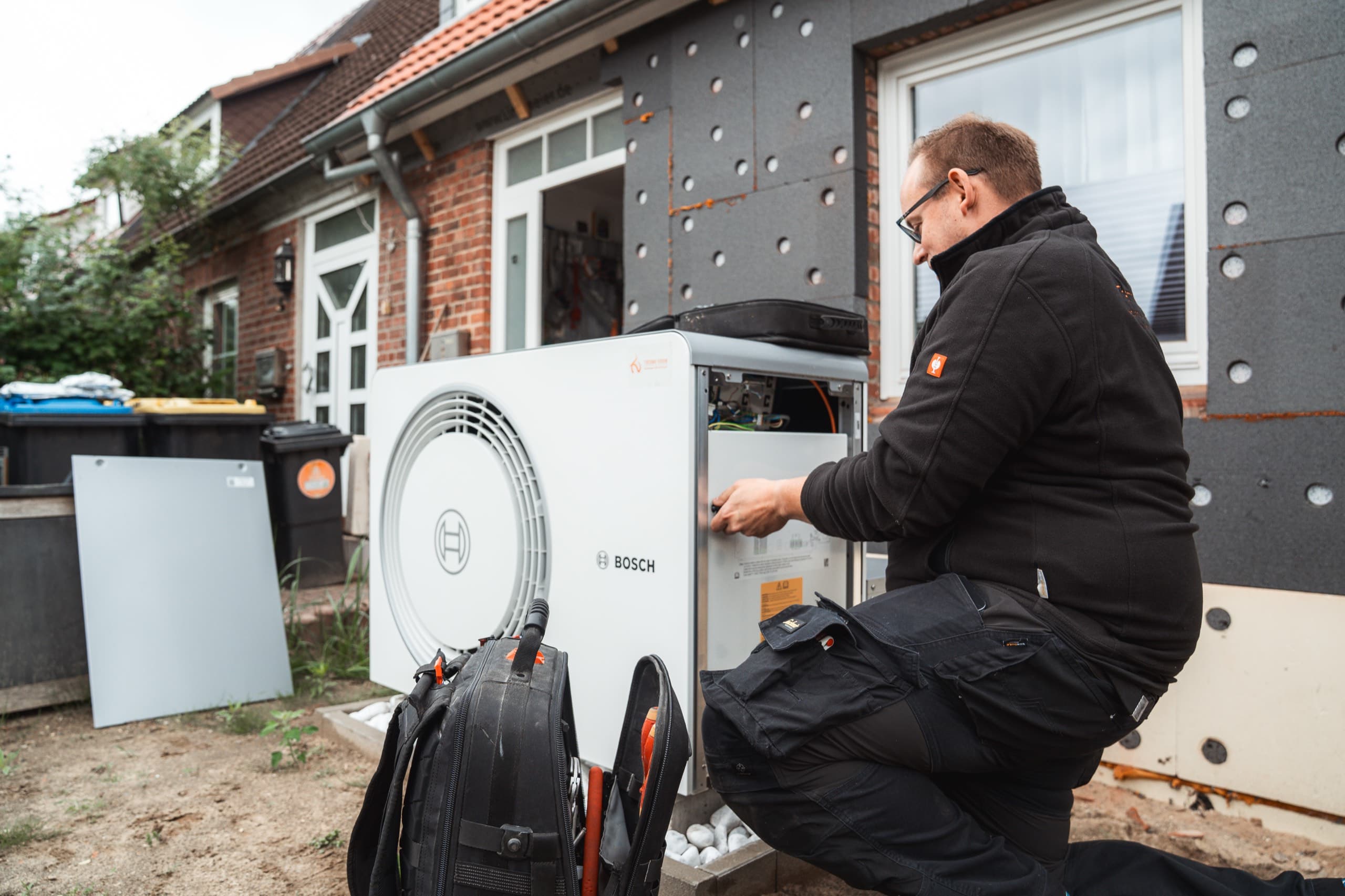 ThermoVision Monteur bei der Inbetriebnahme einer Wärmepumpe an einem Wohnhaus