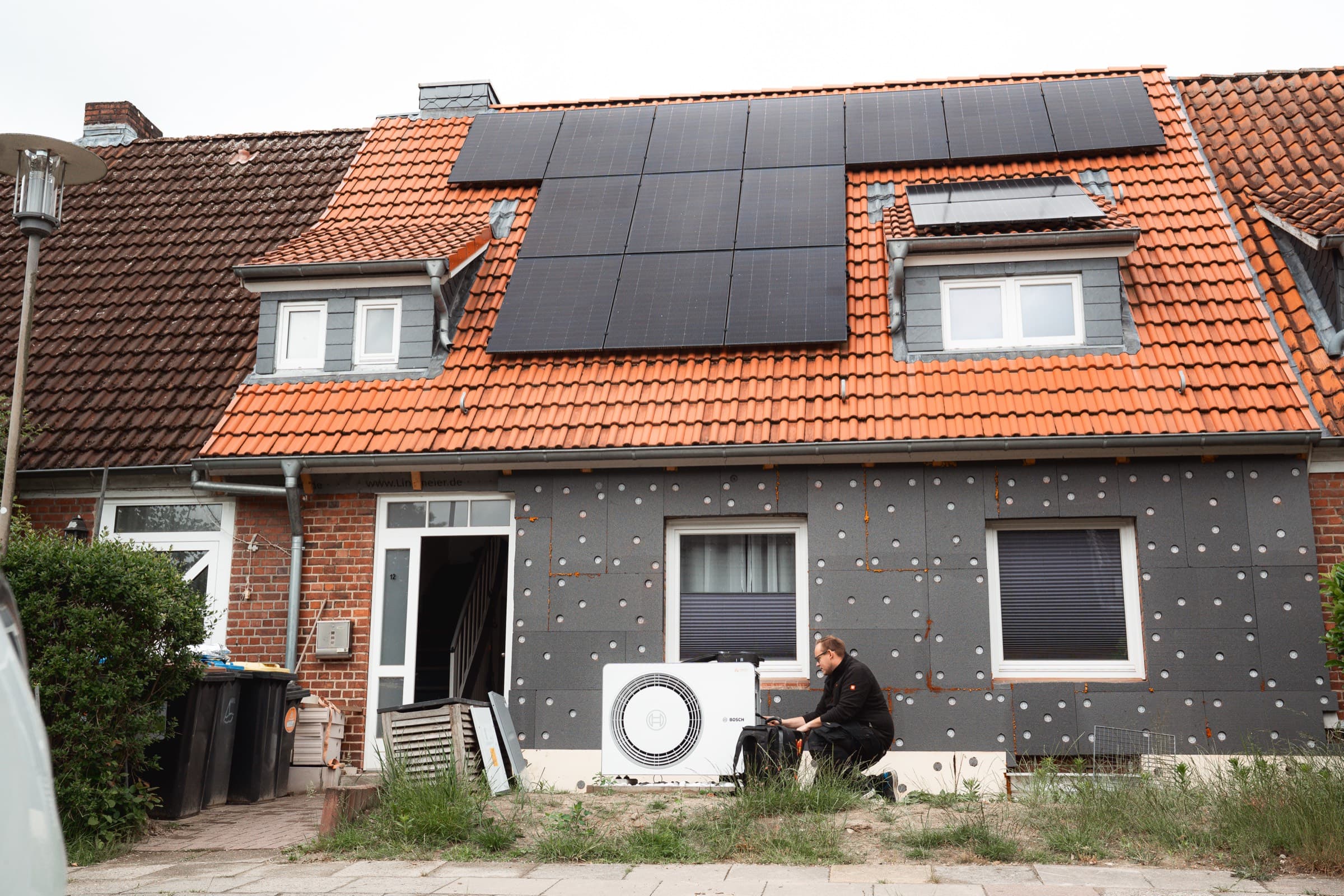 Wohnhaus mit Photovoltaikanlage auf dem Dach und neu installierter Wärmepumpe
